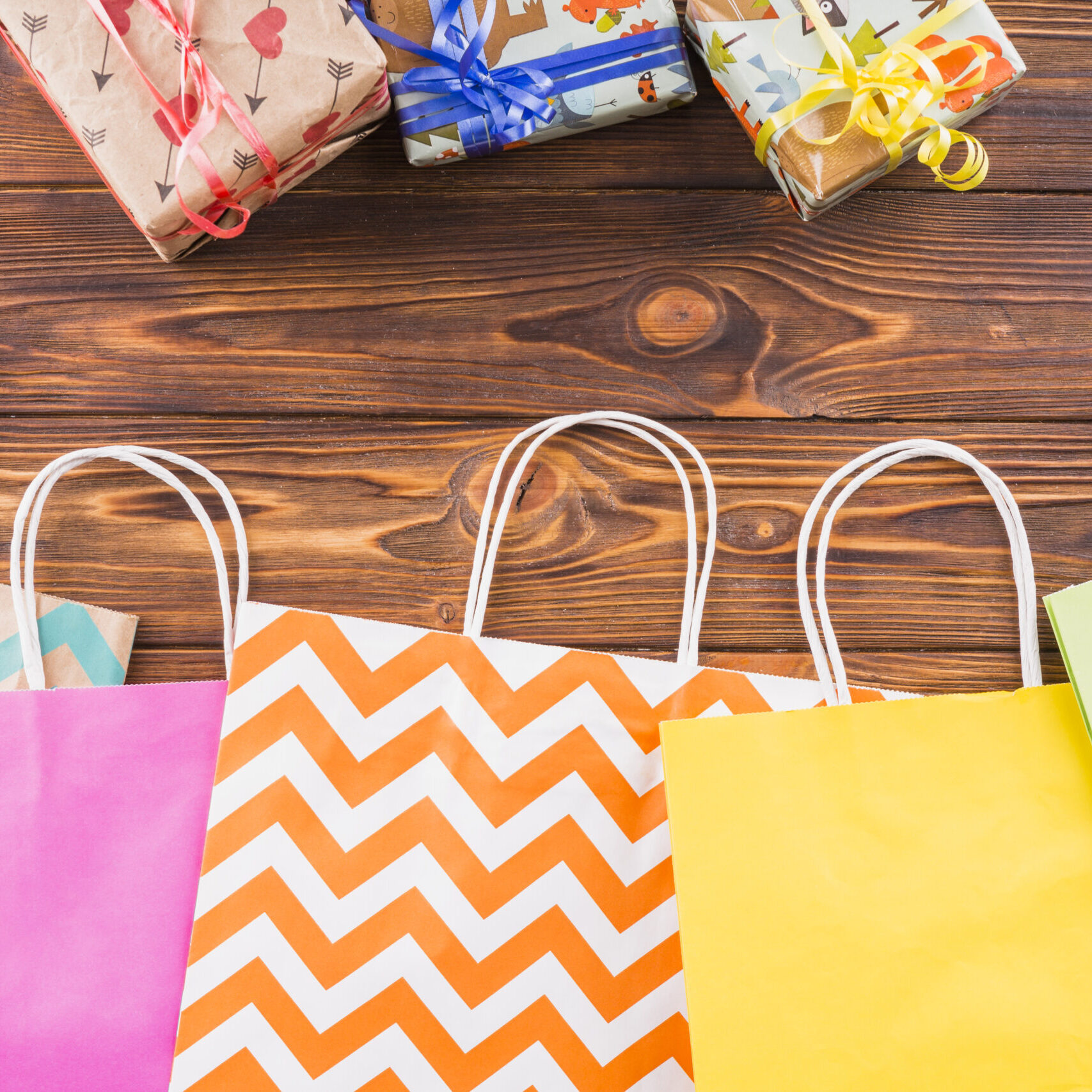 wrapped-gift-decorative-paper-shopping-bag-wooden-surface wrapped-gift-decorative-paper-shopping-bag-wooden-surface